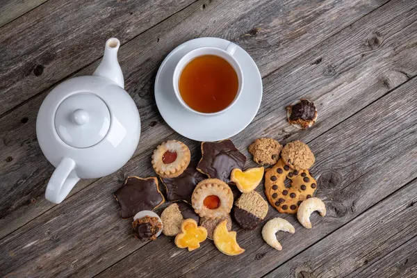 Verschiedene Hausgemachte Kekse Mit Tasse Und Kanne Tee Auf Holzboden — Stockfoto