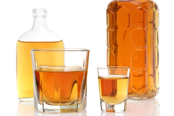 ガラスのコップと白い背景のウイスキーのボトル — ストック写真