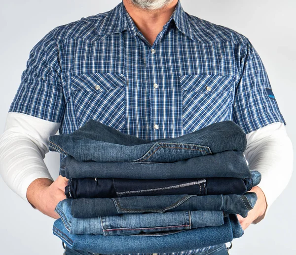 Man Spijkerbroek Blauwe Geruite Shirt Houden Een Stapel Van Jeans — Stockfoto