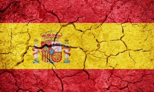 乾燥地球地面テクスチャ背景にスペイン王国旗 — ストック写真