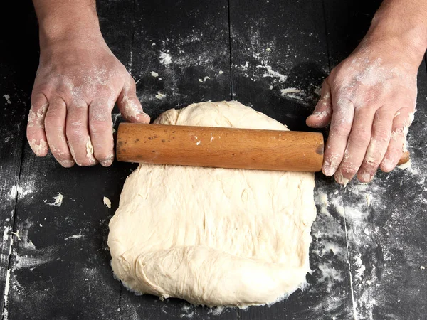 Chef Una Túnica Negra Rueda Una Masa Para Una Pizza —  Fotos de Stock