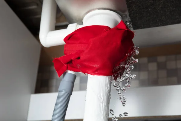 냅킨의 Close Red Napkin Tied Leakage White Sink Pipe — 스톡 사진