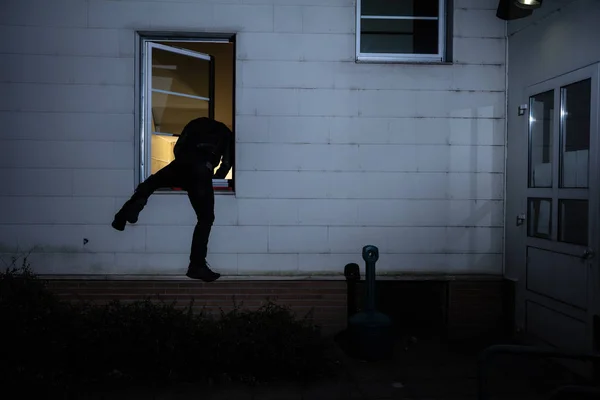Widok Tyłu Burglar Wprowadzając Domu Przez Okno — Zdjęcie stockowe