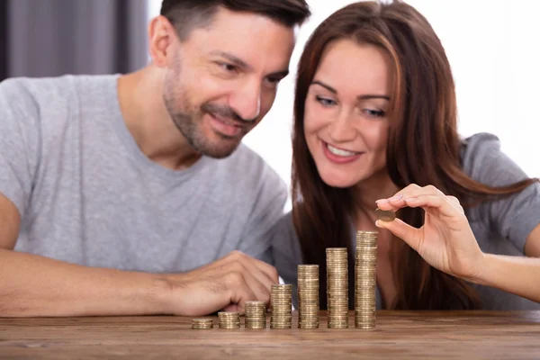 Casal Feliz Empilhando Moedas Sobre Mesa Madeira — Fotografia de Stock