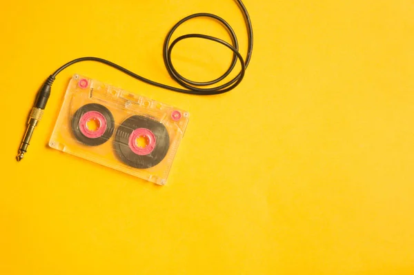 黄色の背景にレトロなカセットテープとオーディオジャック コピースペース — ストック写真