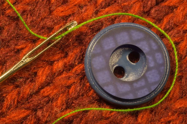 赤い織物の背景に糸のボタンと針 — ストック写真