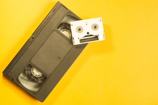 黄色の背景にビデオカセット 小型カセット コピースペース — ストック写真