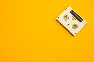 Digital video cassette on yellow background. mini cassette. copy space clipart