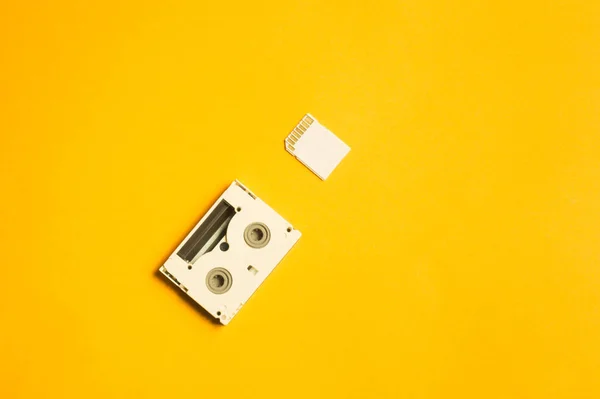 黄色の背景にメモリカードとデジタルビデオカセット コピースペース — ストック写真