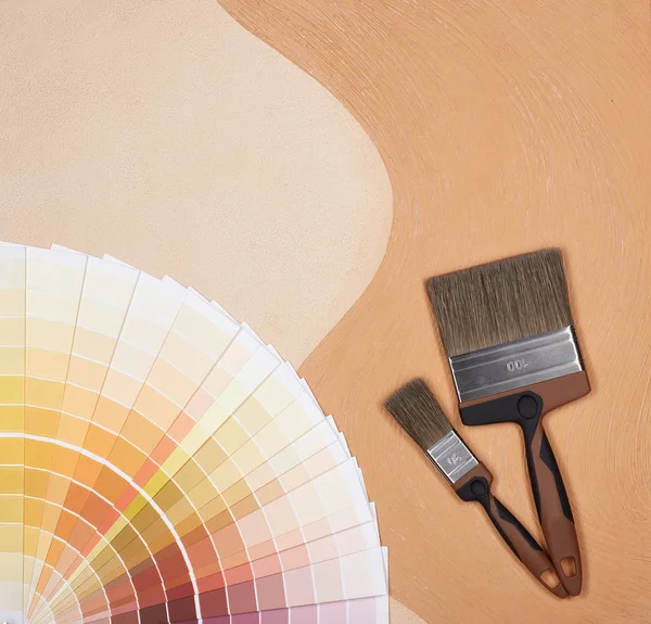 Color palette guide and painting accessories ( paint brushes) on textural double background consisting of two beige shades. Top view with copy space, Concept of construction or design office