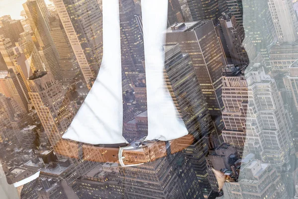 Corporate business, entrepreneurship and economic prosperity conceptul collage. Businessman wearing fashionable classic navy blue suit against new york city buildings and skyscrapers.