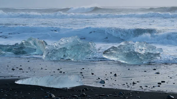 冰上在黑色的沙子钻石海滩与海的背景 Joekulsarlon — 图库照片