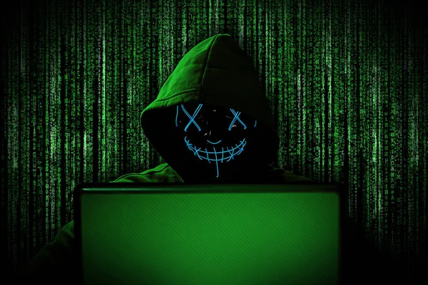Haker Świecącą Maską Notebooka Laptop Przed Zielonym Źródłem Kodu Binarnego — Zdjęcie stockowe