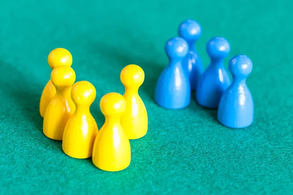 Escena Conceptual Varios Peones Amarillos Frente Pocos Peones Azules Mesa —  Fotos de Stock