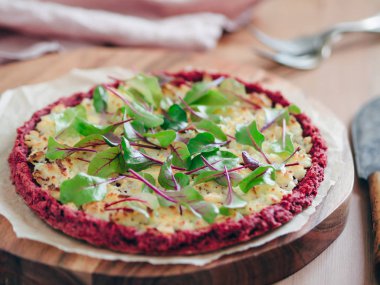 beetroot pizza crust with fresh swiss chard or mangold, beetroot leaves. Ideas and recipes for vegan snack.Egg-free pizza crust with chia seeds and wholegrain brown rice flour. Copy space. Shallow DOF clipart