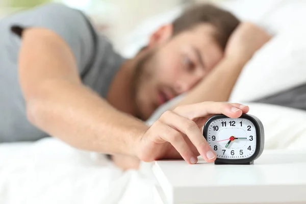 Tired Man Turning Alarm Clock Lying Bed Morning — Stock Photo, Image