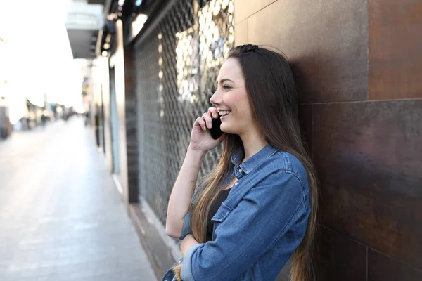 一个快乐的女孩配置文件在街上打电话的侧视图肖像 — 图库照片
