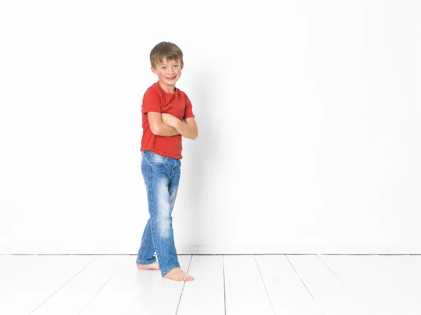 Słodkie Blond Chłopiec Czerwonej Koszuli Niebieskie Dżinsy Jest Pozowanie Białej — Zdjęcie stockowe