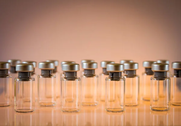 橙色背景的疫苗玻璃瓶组 — 图库照片