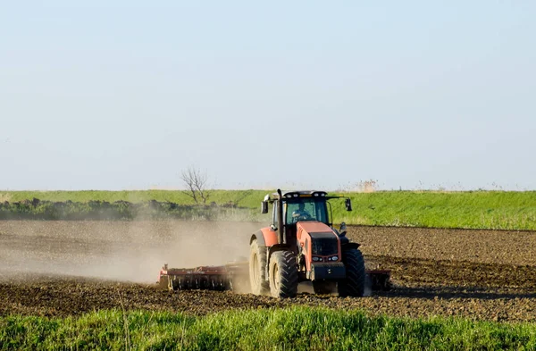 耕起のあるトラクターが土を耕す 播種のためのフィールド上の土壌栽培 — ストック写真