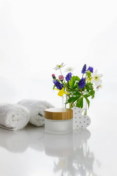 Handtücher Neben Einem Cremeglas Vor Weißem Hintergrund Und Blumen Einer — Stockfoto
