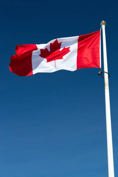 加拿大国旗挂在明澈蓝天的旗杆上 — 图库照片