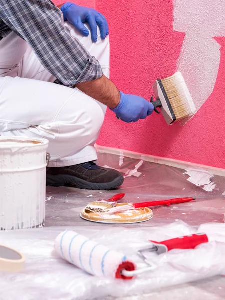Καυκάσιος Εργάτης Ζωγράφου Λευκές Φόρμες Βούρτσα Ζωγραφίζει Τον Ροζ Τοίχο — Φωτογραφία Αρχείου