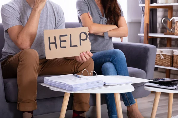 Jonge Paar Zittend Sofa Holding Help Sign Tijdens Het Berekenen — Stockfoto