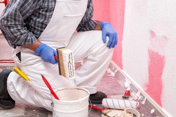 白い全体で白人の家の画家の労働者は ピンクの壁をペイントするために白い塗料を準備します 建設業 作業安全 — ストック写真