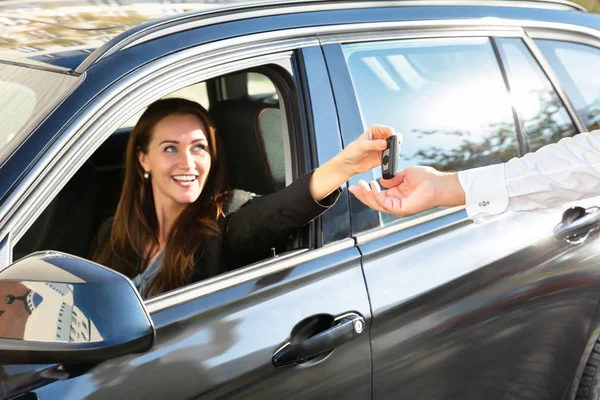 Sorridente Giovane Donna Seduta Auto Dando Chiave Auto Mano Maschile — Foto Stock