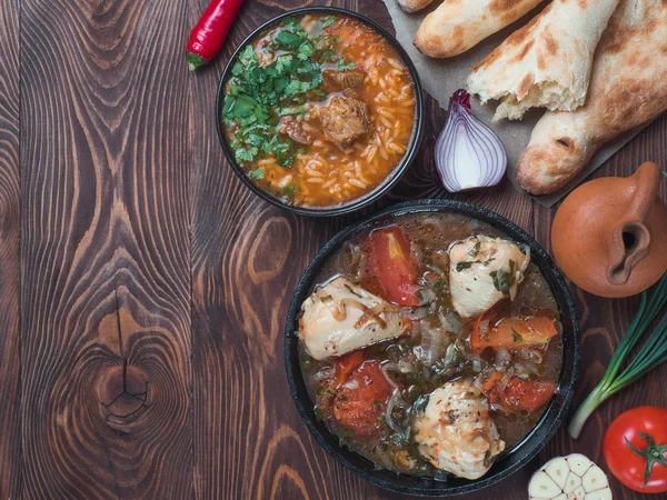 传统的格鲁吉亚厨房 辛辣的 Kharcho 汤和鸡肉 Chachochbili 传统的面包 Shochtis Puri 老式的酒罐 木桌上的新鲜蔬菜 — 图库照片