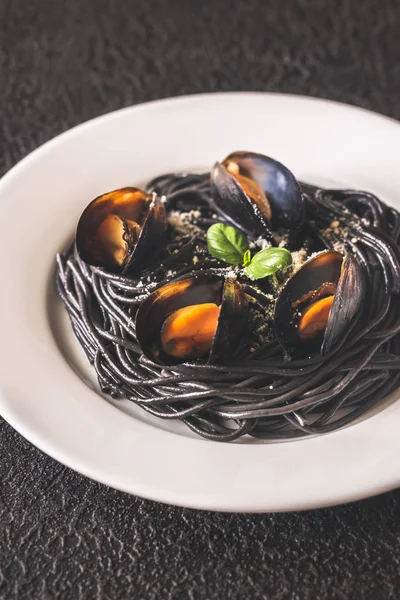 Schwarze Nudeln Mit Miesmuscheln Und Parmesan Auf Dem Weißen Teller — Stockfoto