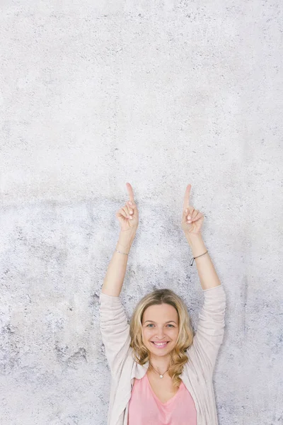 Mooie Blonde Vrouw Wijst Naar Poseren Voorkant Van Grijze Achtergrond — Stockfoto