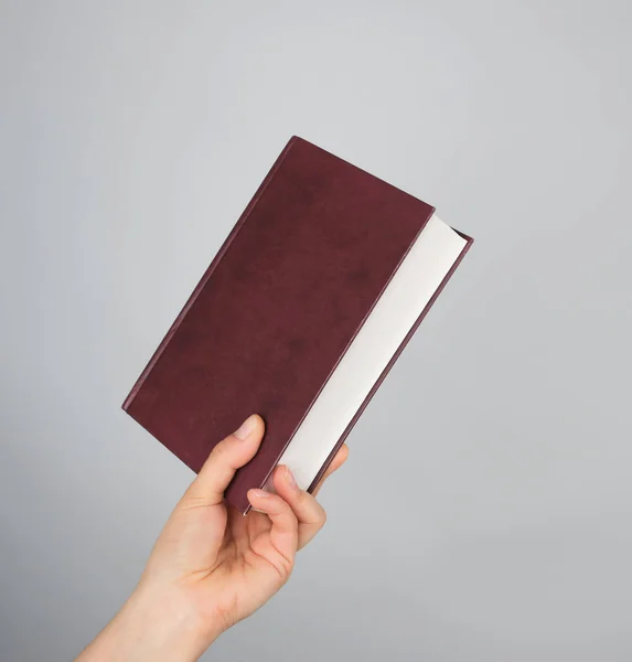 Hand Holds Closed Brown Book Hardcover Gray Background — Stock Photo, Image