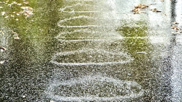 道路上の豪雨時に 一定の間隔で大きな円 楕円形が形成されています 雨によって引き起こされる異常な形状形成 またテクスチャを使用する背景として — ストック写真