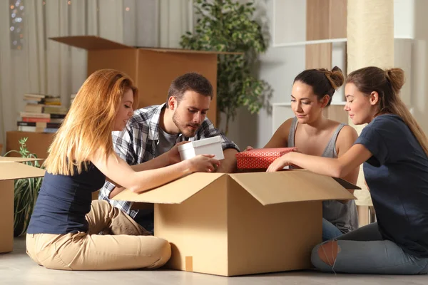 Quatro Companheiros Quarto Sérios Unboxing Pertences Movendo Para Casa Sentado — Fotografia de Stock
