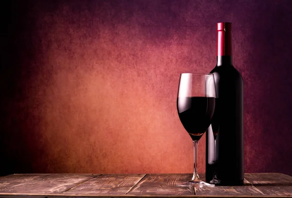テクスチャの背景にワイングラスとワインのボトル — ストック写真
