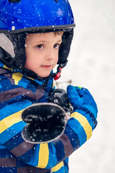 一个戴着滑雪头盔拿着滑雪板的可爱白人小男孩的冬季肖像 — 图库照片