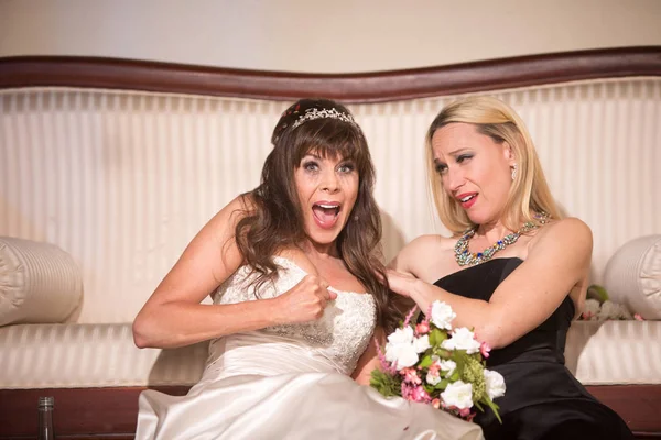 Friend comforting sad bride at a wedding