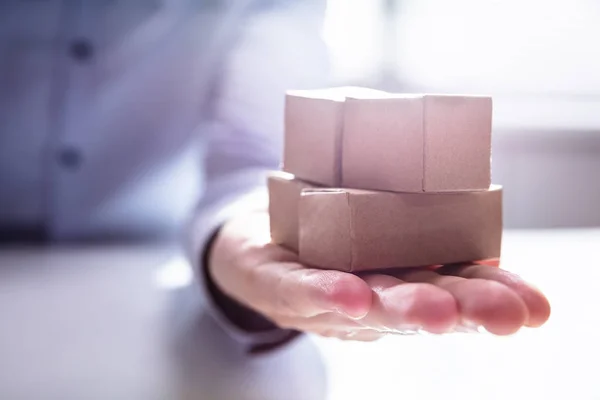 Close Hand Holding Stack Miniature Movable Cardboard Boxes Desk — Stock Photo, Image