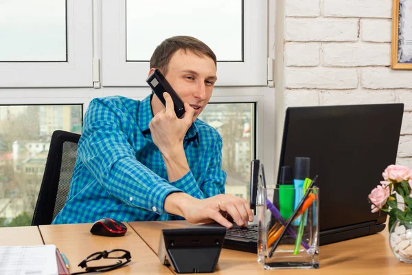 Jovem Trabalhador Escritório Falando Telefone Trabalhando Laptop — Fotografia de Stock