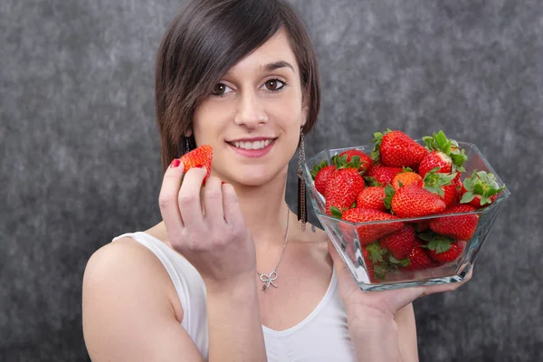 一个漂亮的年轻黑发女人吃草莓 — 图库照片