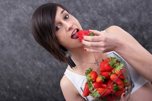 一个漂亮的年轻黑发女人吃草莓 — 图库照片