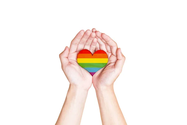 白い背景の上に孤立したLgbtの象徴として虹の旗で心を保持する人間の手 — ストック写真