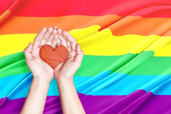 Mãos Humanas Segurando Coração Com Fundo Bandeira Arco Íris Conceito — Fotografia de Stock