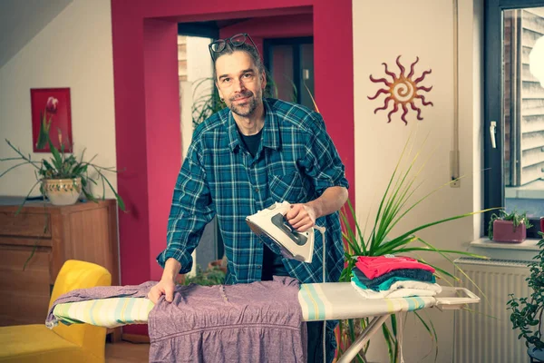 Hombre Con Plancha Sobre Tabla Planchar Con Clothers Salón — Foto de Stock