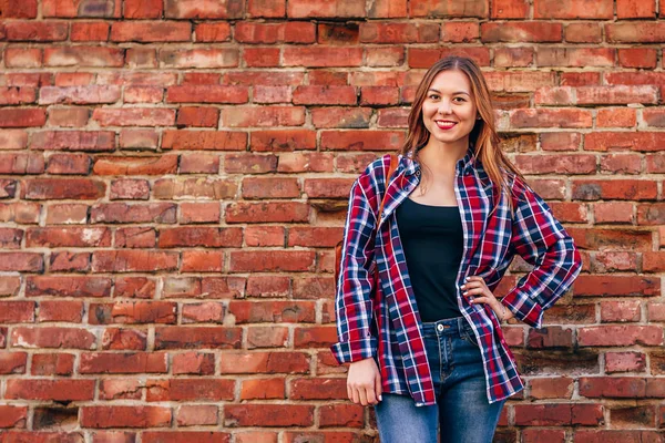 Портрет Молодой Женщины Клетчатой Рубашке Синих Джинсах Стоящих Напротив Стены — стоковое фото