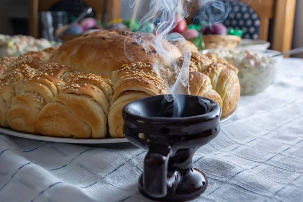 食べ物とテーブルの上のクレセットから立ち上がる煙がOrtodoxイースター — ストック写真