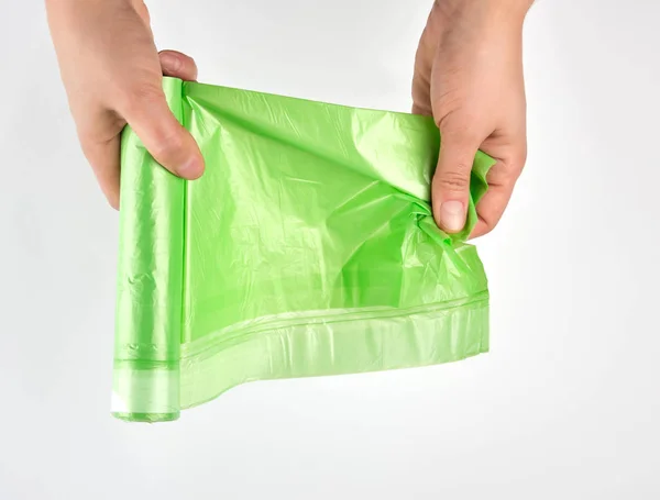 Female Hand Unwind Green Roll Plastic Bags Garbage White Background — Stock Photo, Image