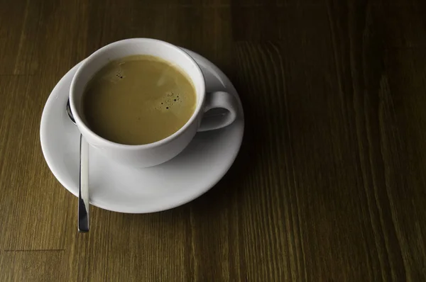 Kahverengi Bir Masaya Bir Fincan Kahve Kaşık — Stok fotoğraf